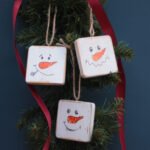A set of 3 rustic tree hanger decorations with snowman faces