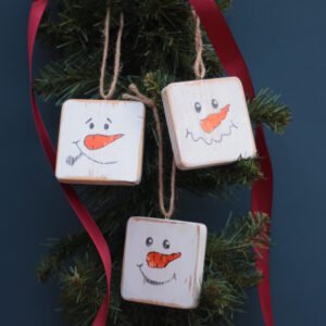 A set of 3 rustic tree hanger decorations with snowman faces