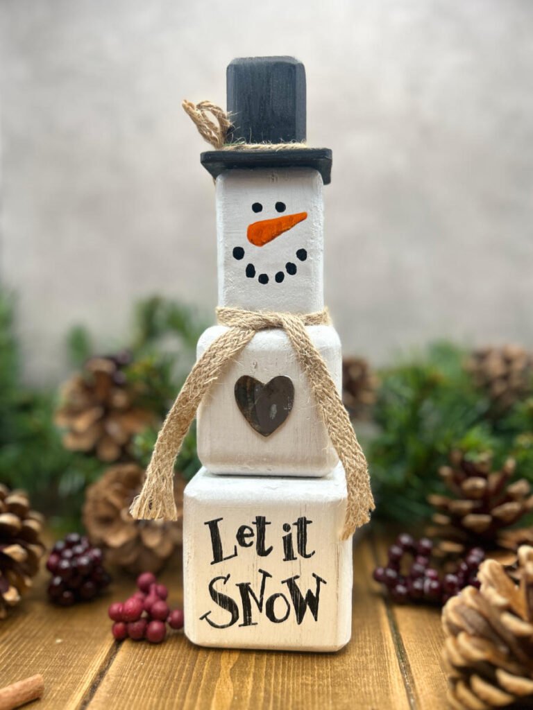 A rustic Snowman ornament made from wooden blocks