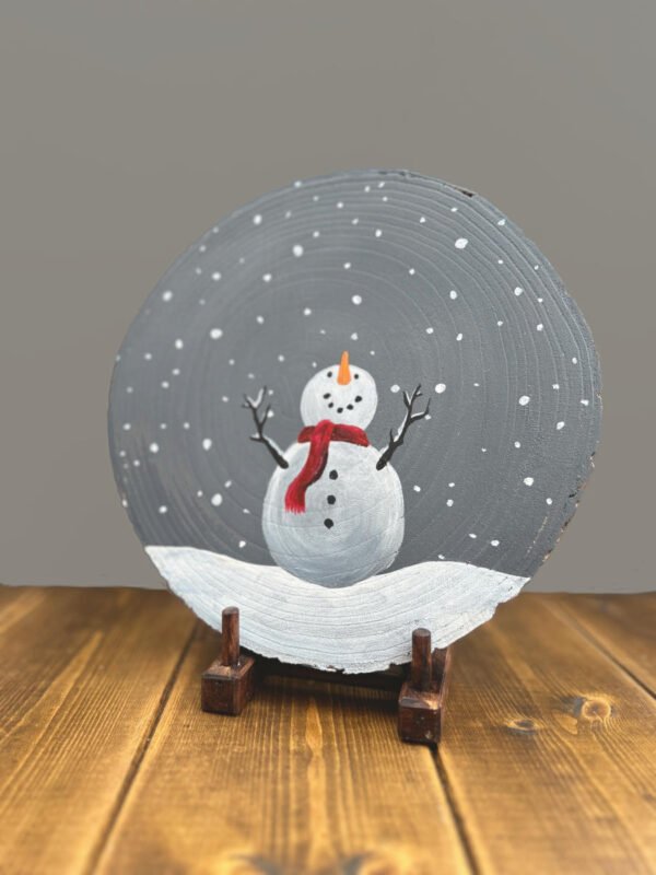 A christmas Snowman painted on a wooden slab